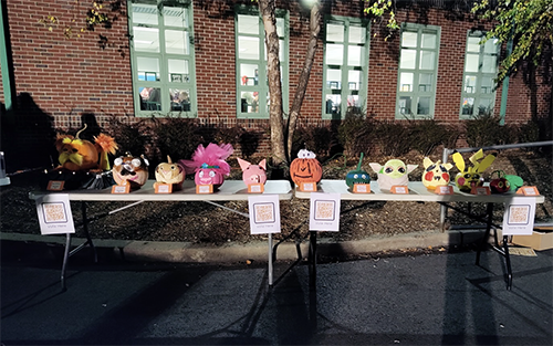 Student pumpkins displayed on a table outside