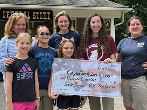 Group of fourth graders and adults holding a big check