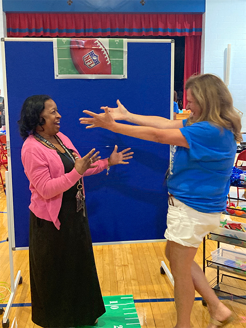 Two teachers about to hug each other