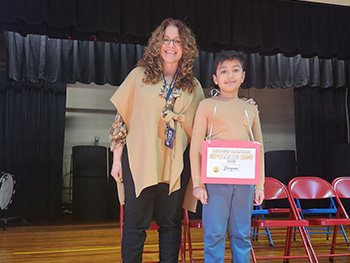 Ridge Ranch spelling bee champion Divyam Gajera with staff member