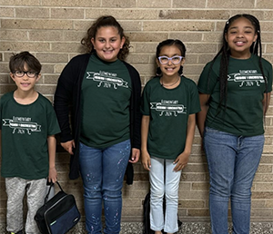 Four orchestra students in green shirts and jeans