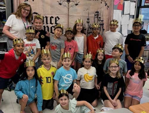 students and teacher with crowns on their heads