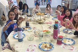 Students holding teacups up