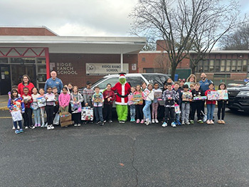 Students in the parking lot with police officers and the Grinch