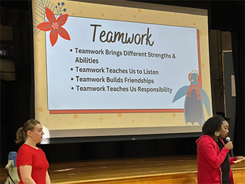 Rockette giving a presentation in front of a large presentation screen