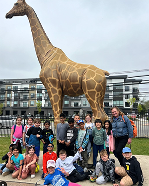 Ridge Ranch second graders beside giraffe statue