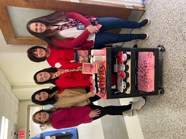 Happy women next to cart with hot chocolate and treats for teachers
