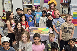 Students around a United States cake