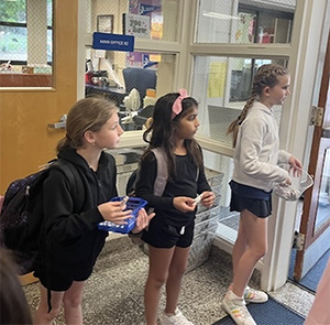 three students in a hallway